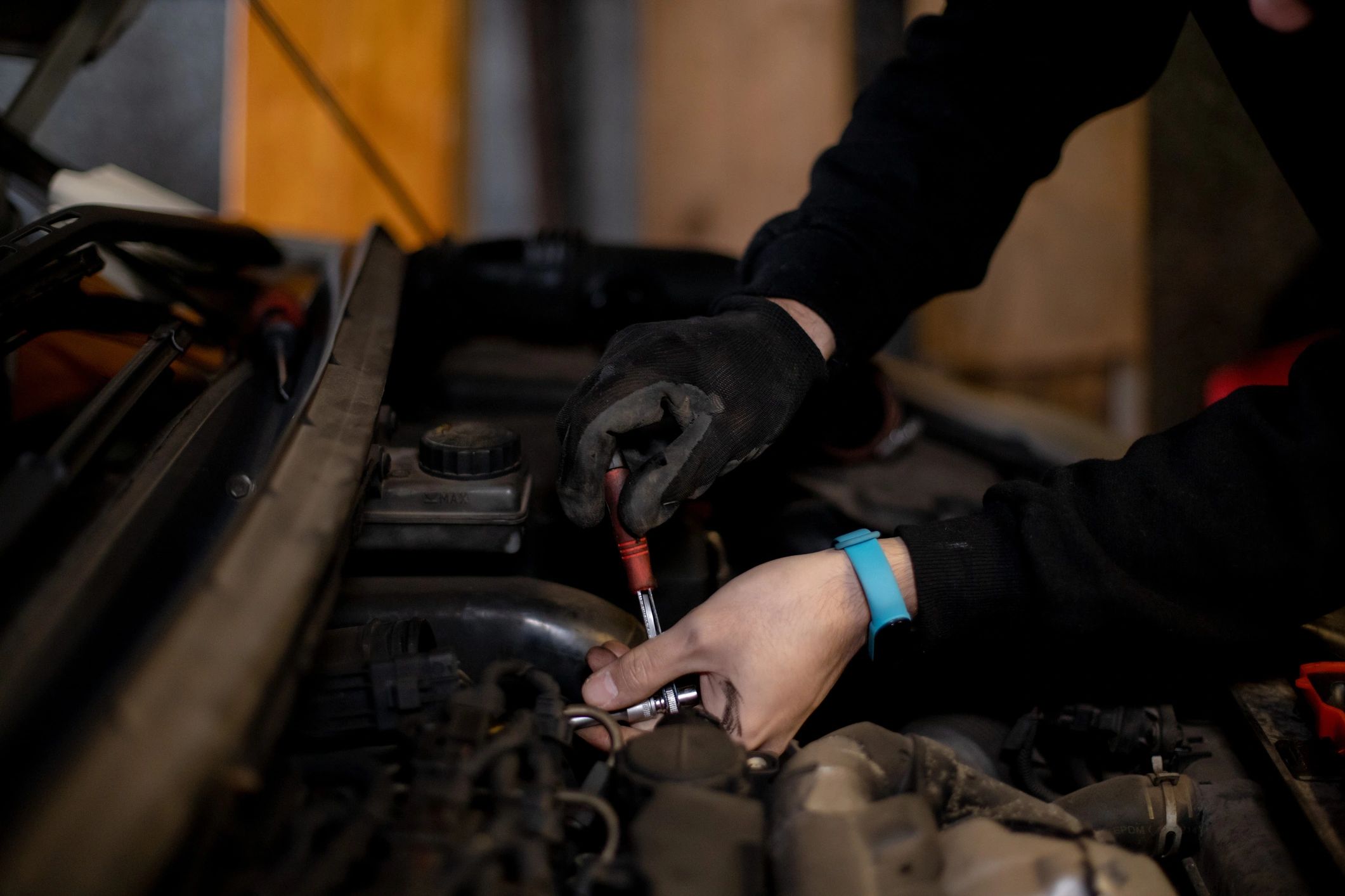 Automotive mechanic working on a vehicle engine